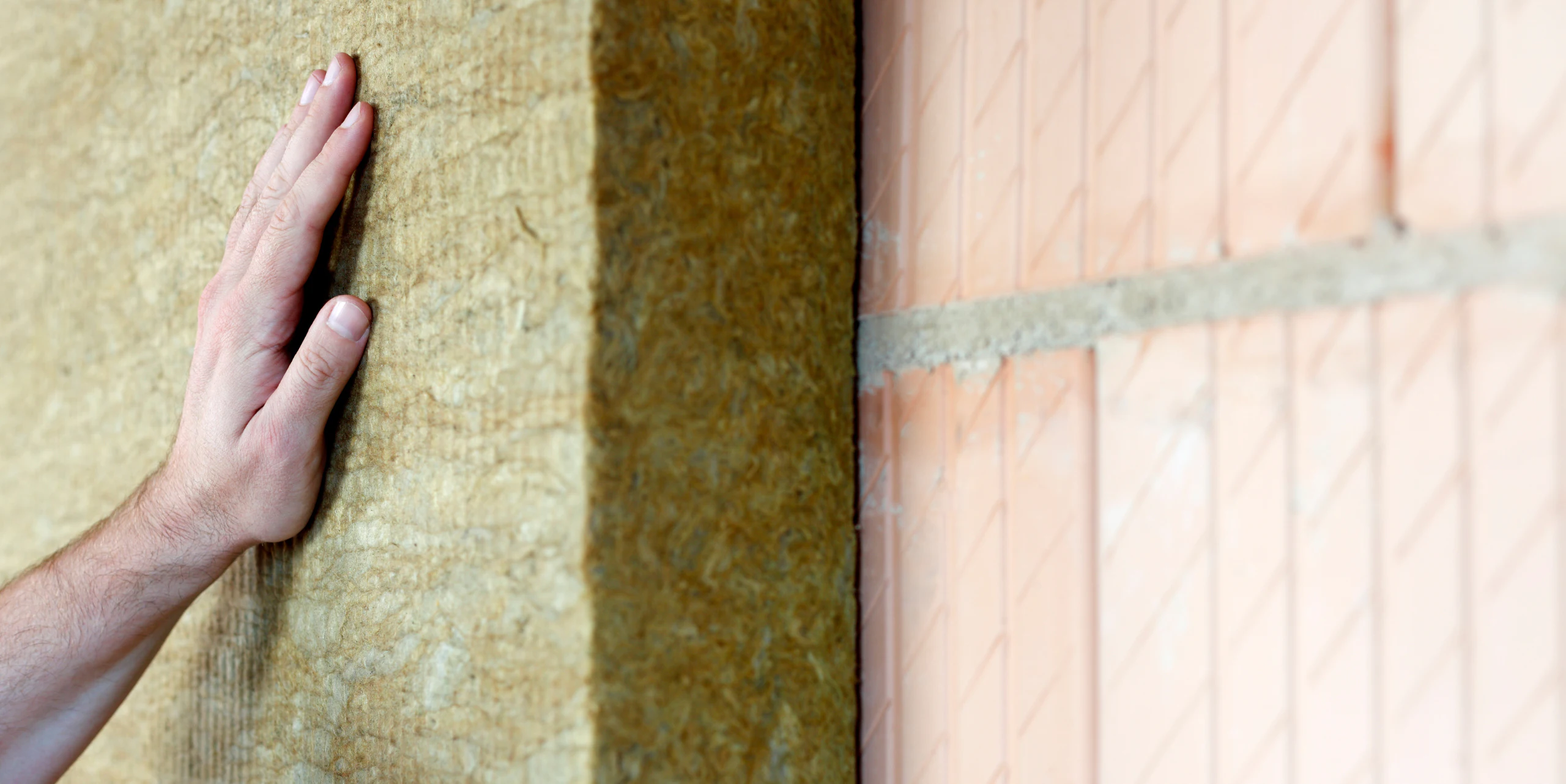 a hand placed against the dense packing insulation